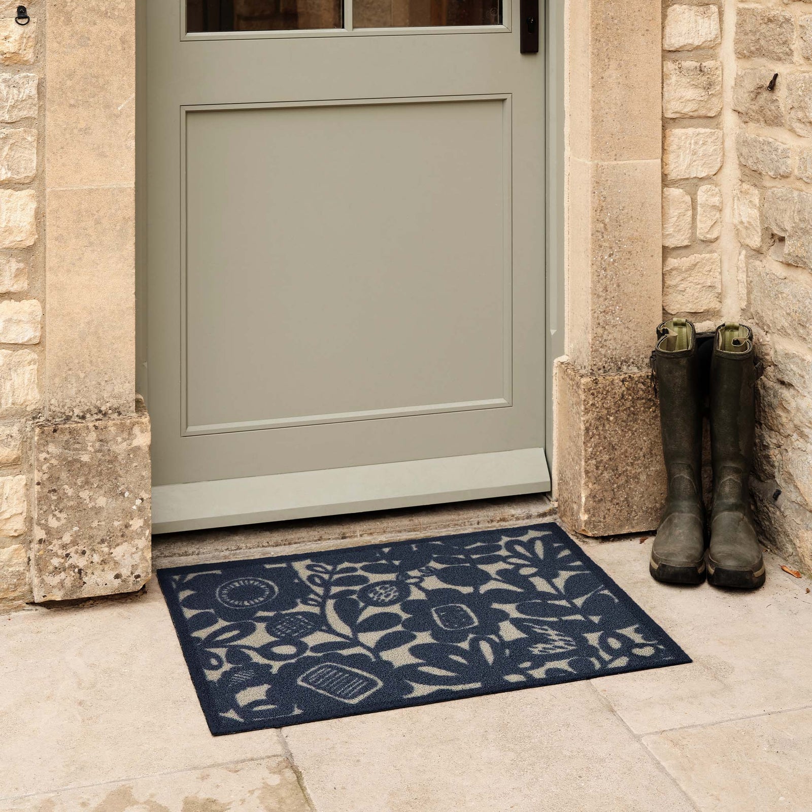 Kukkia Dark Navy Outdoor Doormat. Made from ECONYL regenerated yarn featuring a navy floral pattern.