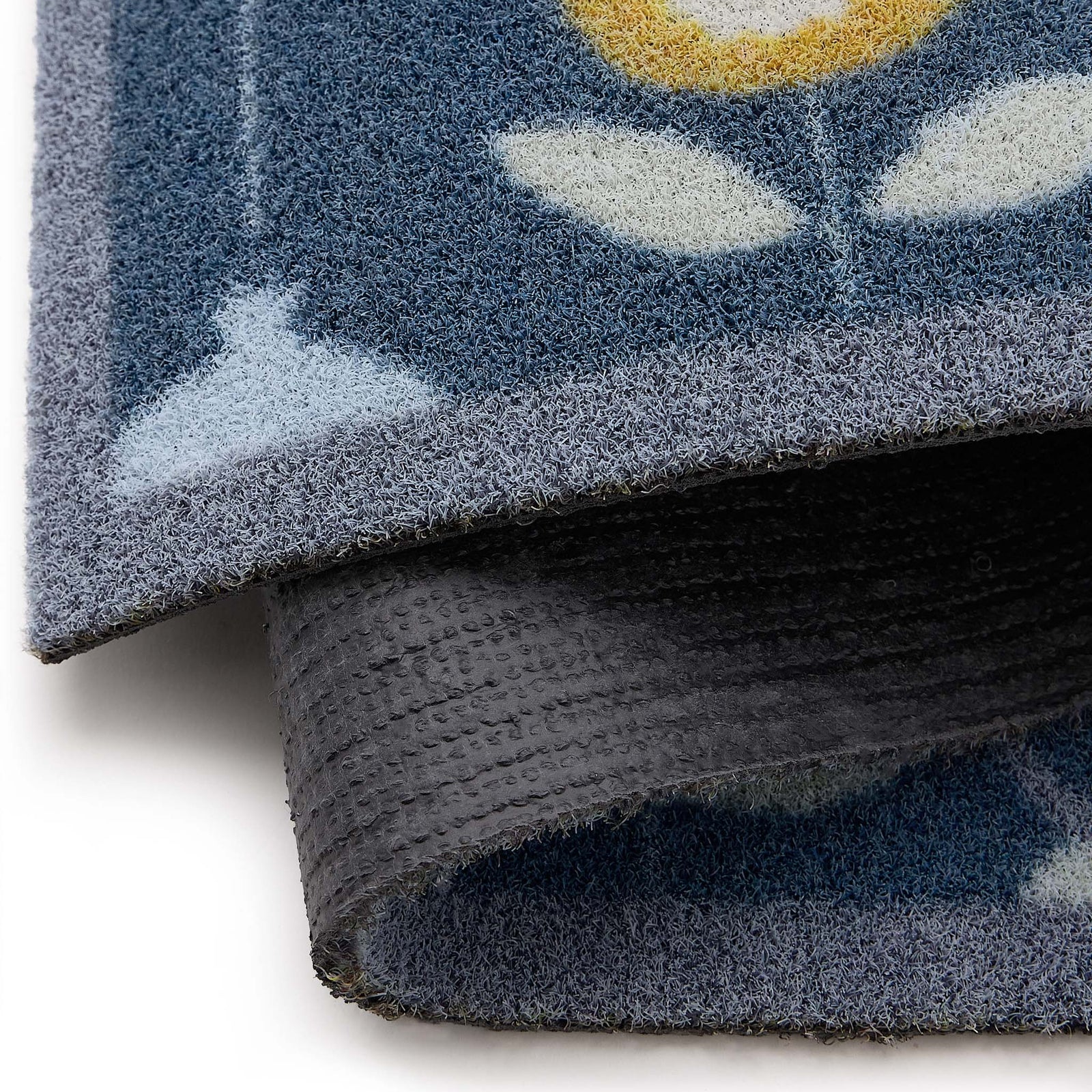 Scion Pepino Blue Outdoor Doormat with a floral design, styled with backing showing.