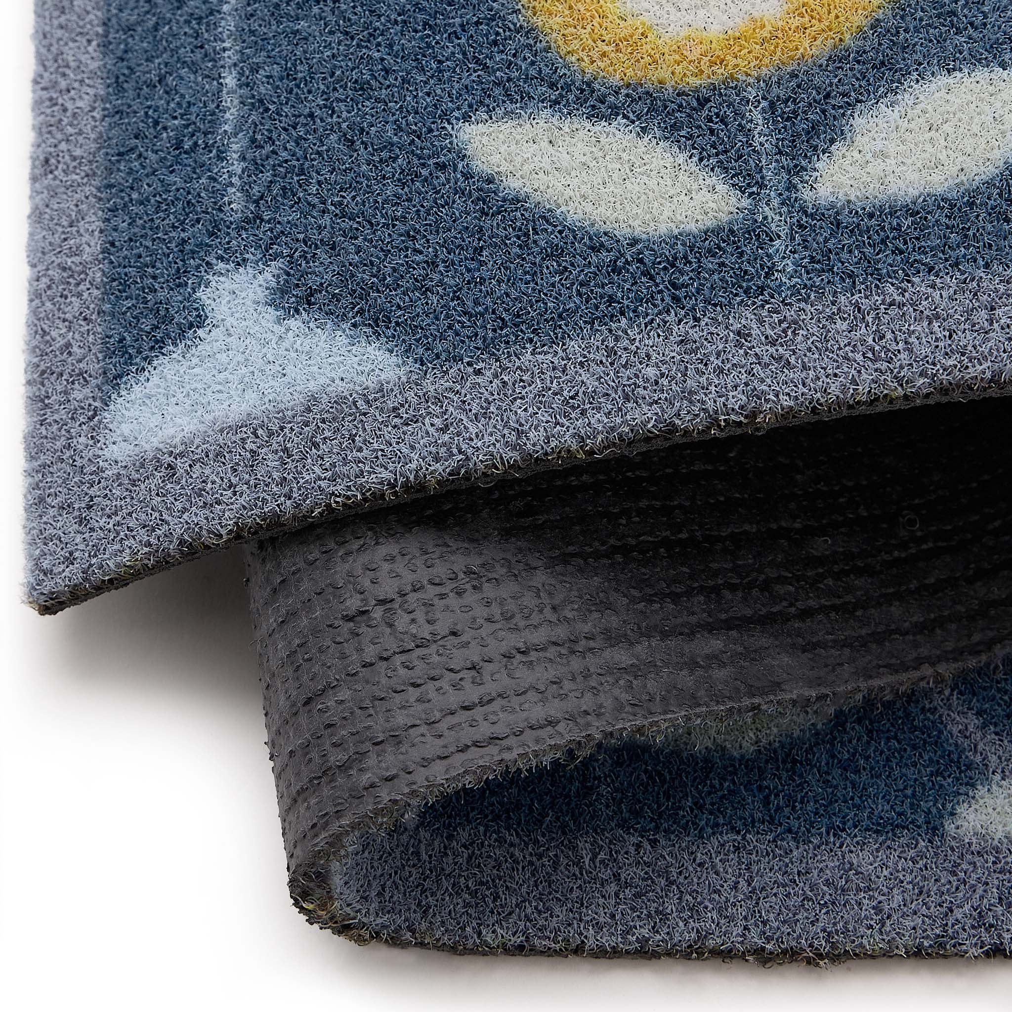 Scion Pepino Blue Outdoor Doormat with a floral design, styled with backing showing.
