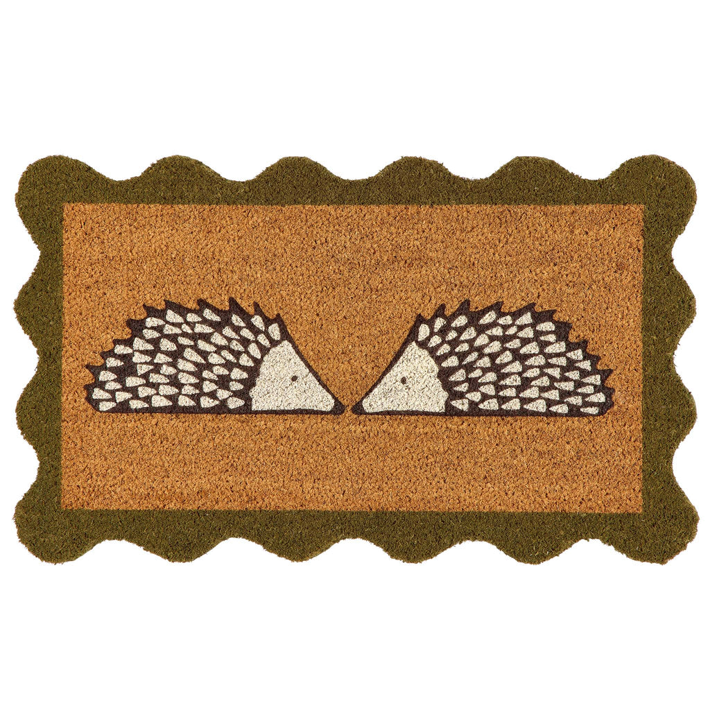 A rectangular coir doormat with a scalloped dark green border and a central design of two facing hedgehogs on a natural background, isolated on a white backdrop.