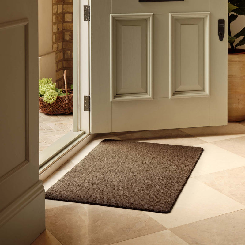 Sense Stone Washable Doormat in brown, styled in a doorway. 