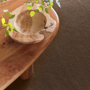 Sense Stone Washable Rug in Brown, styled under a wooden table.