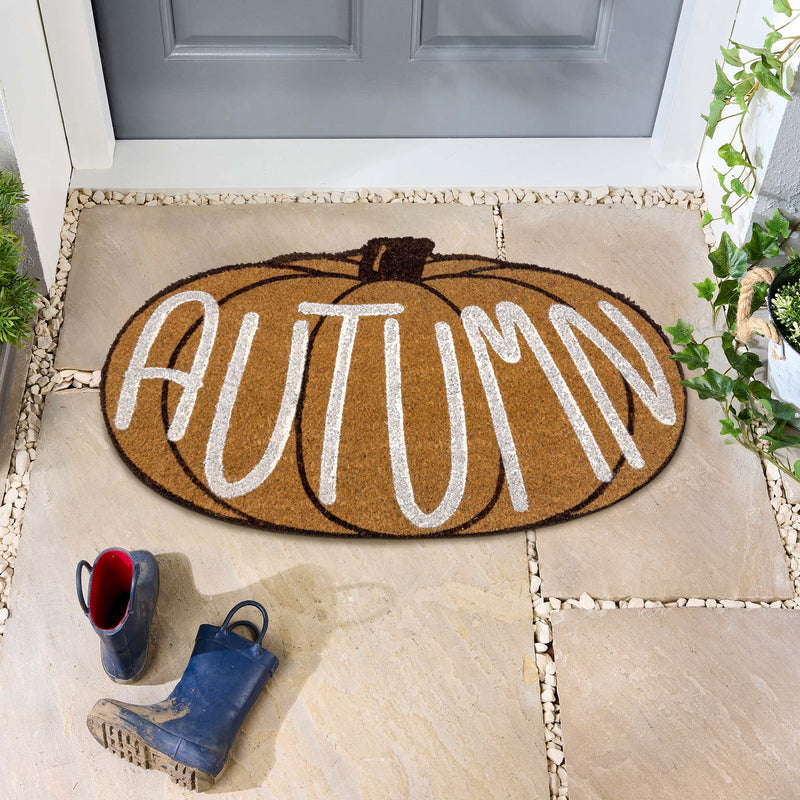Shaped Autumn Pumpkin Coir Doormat, styled on stone flooring.