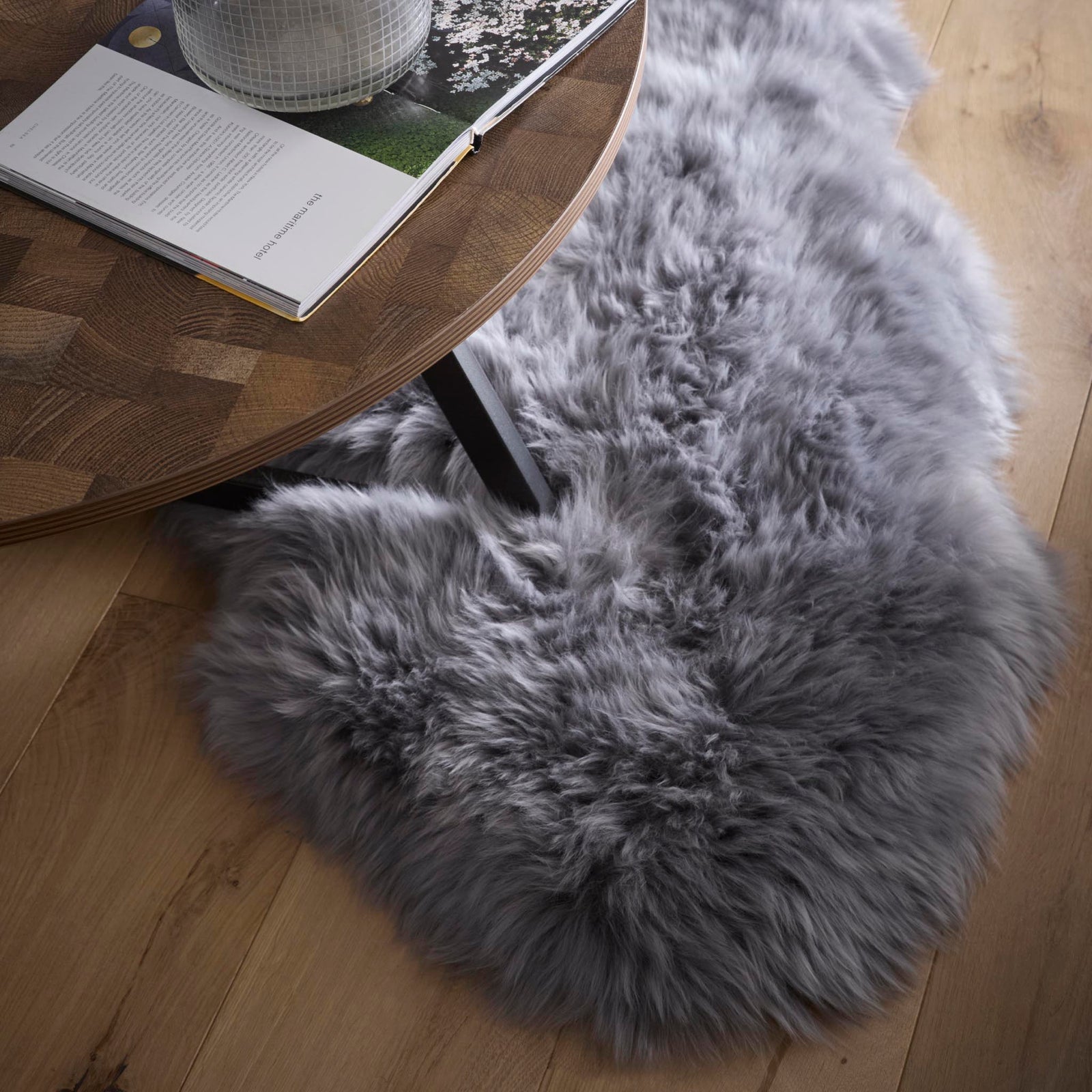 Close-up of double Sheepskin Grey Rug made from long-haired wool, styled on wooden flooring.
