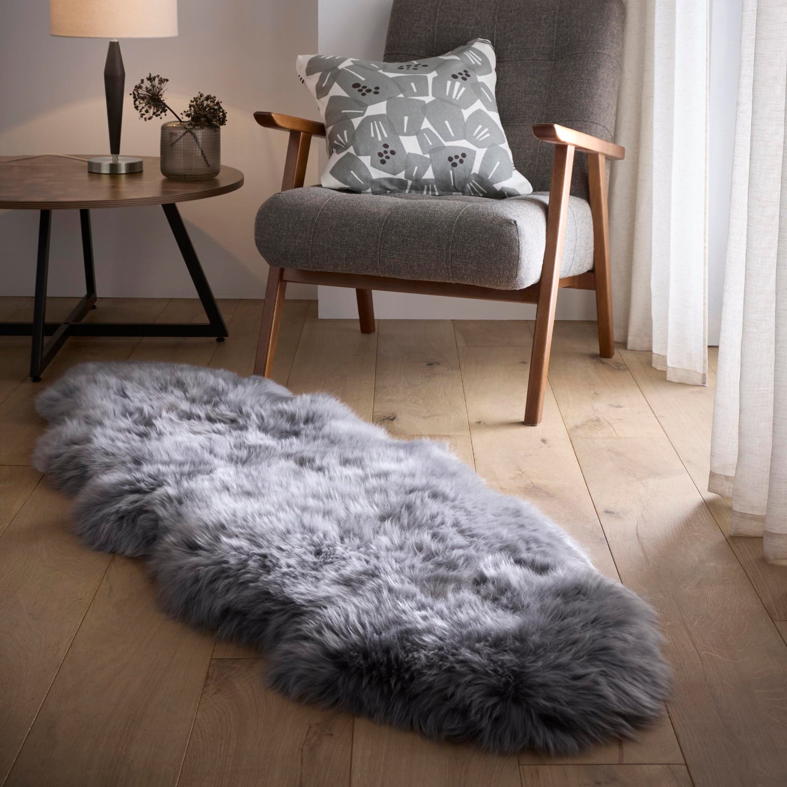 Double Sheepskin Grey Rug made from long-haired wool, styled on wooden flooring.