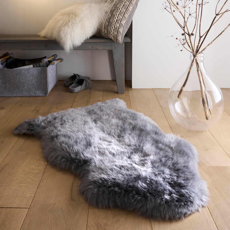 Double Sheepskin Grey Rug made from long-haired wool, styled on wooden flooring.