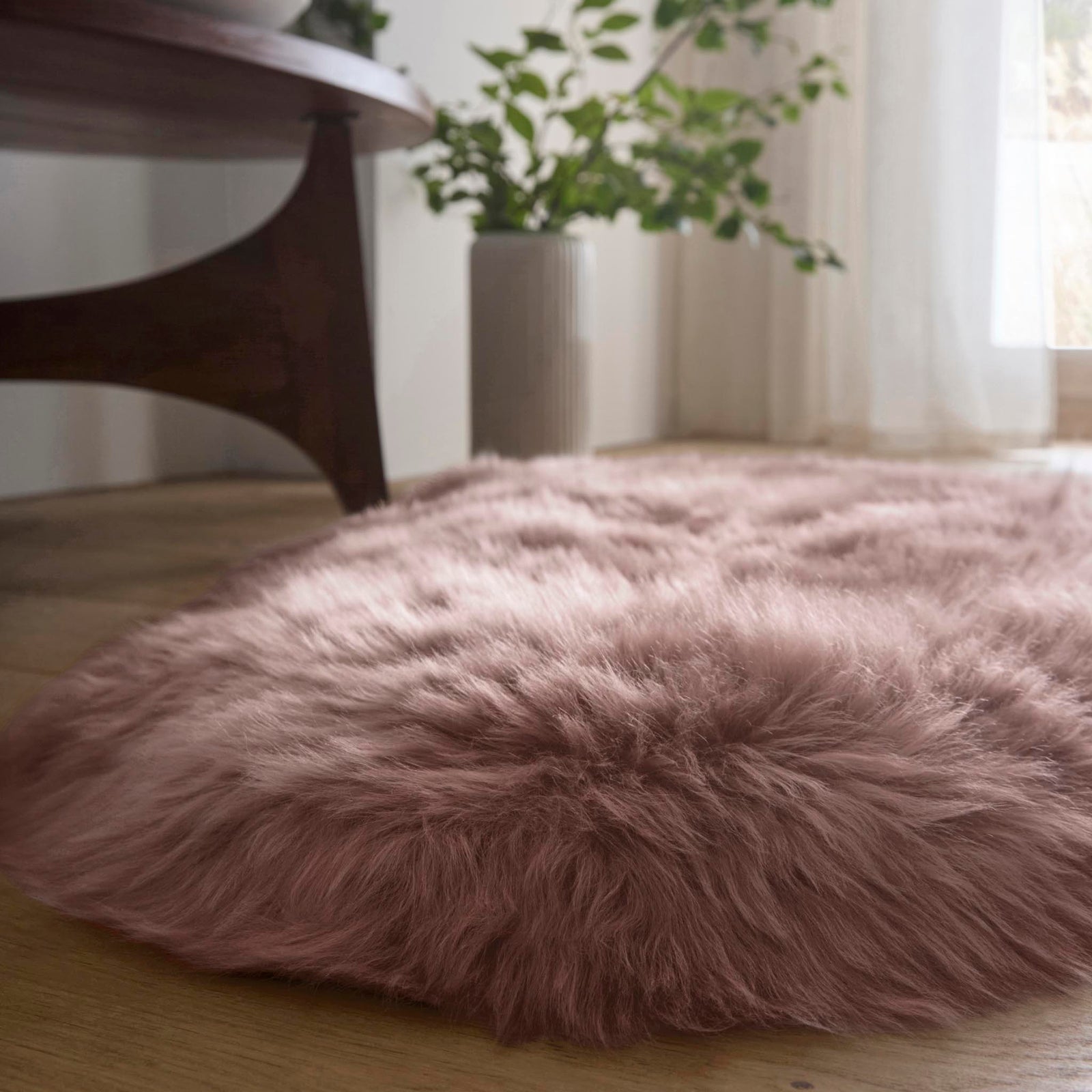 Double Sheepskin Rose Pink Rug showing pile height, styled on wooden flooring.
