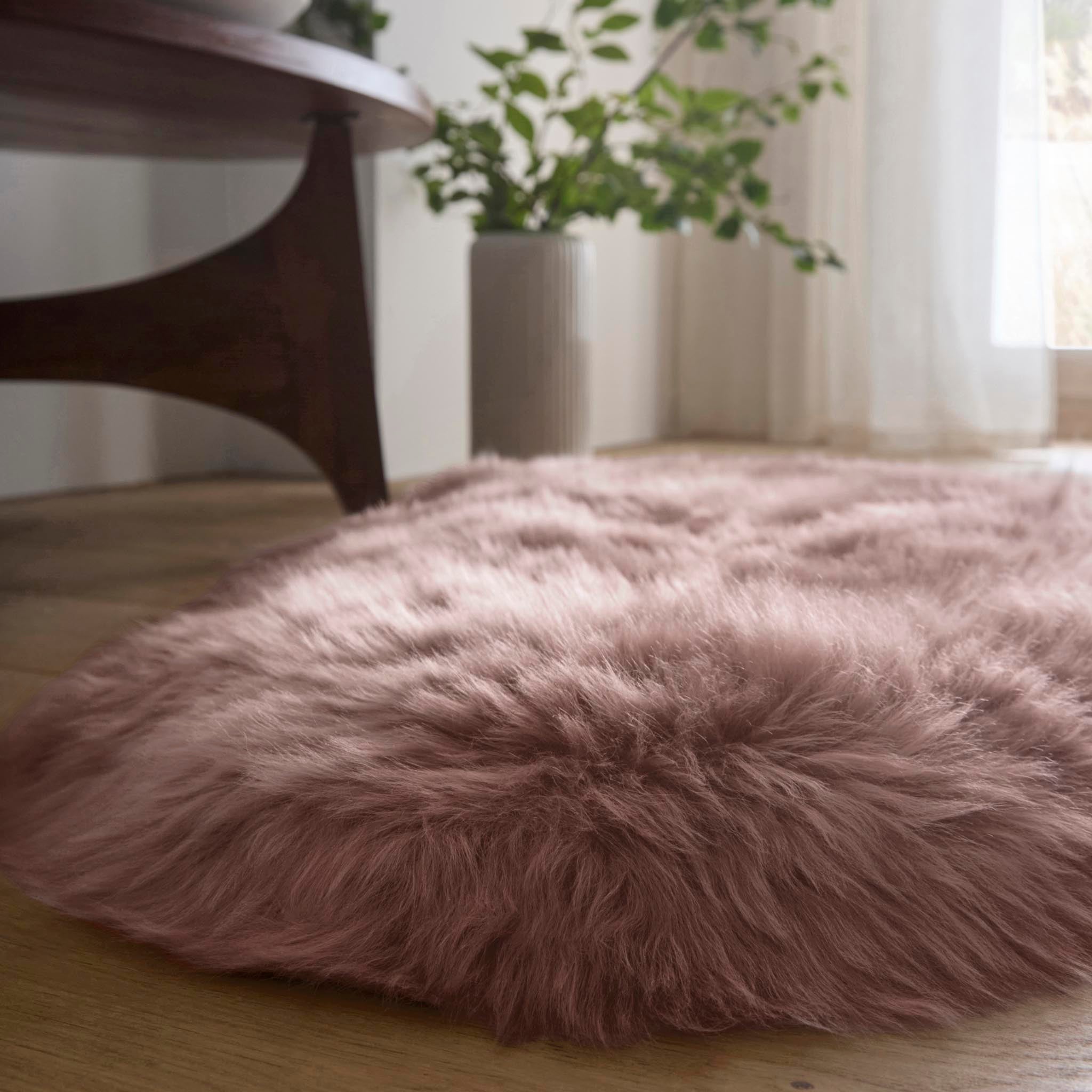 Double Sheepskin Rose Pink Rug showing pile height, styled on wooden flooring.