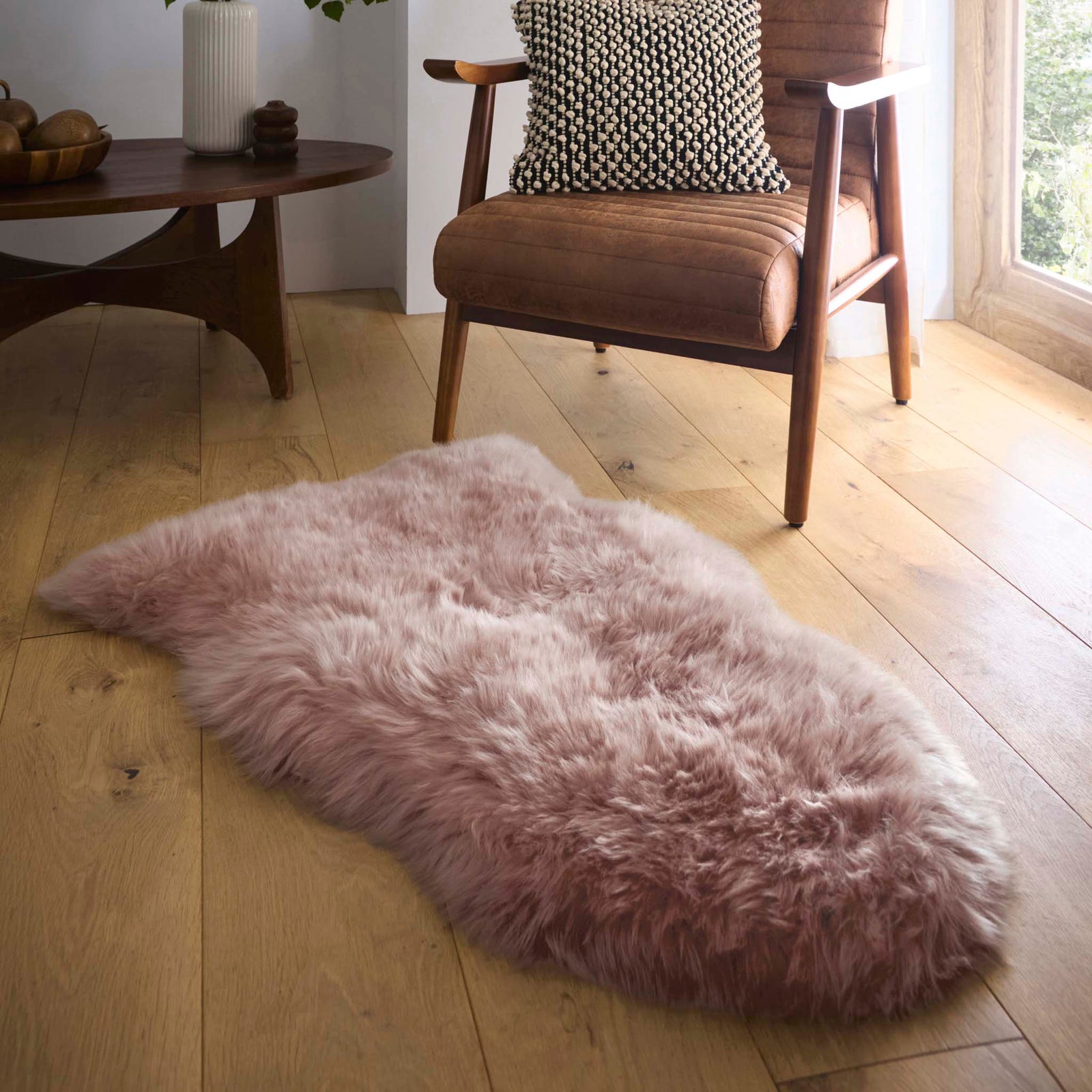 Single Sheepskin Rose Pink Rug made from long-haired wool, styled on wooden flooring.