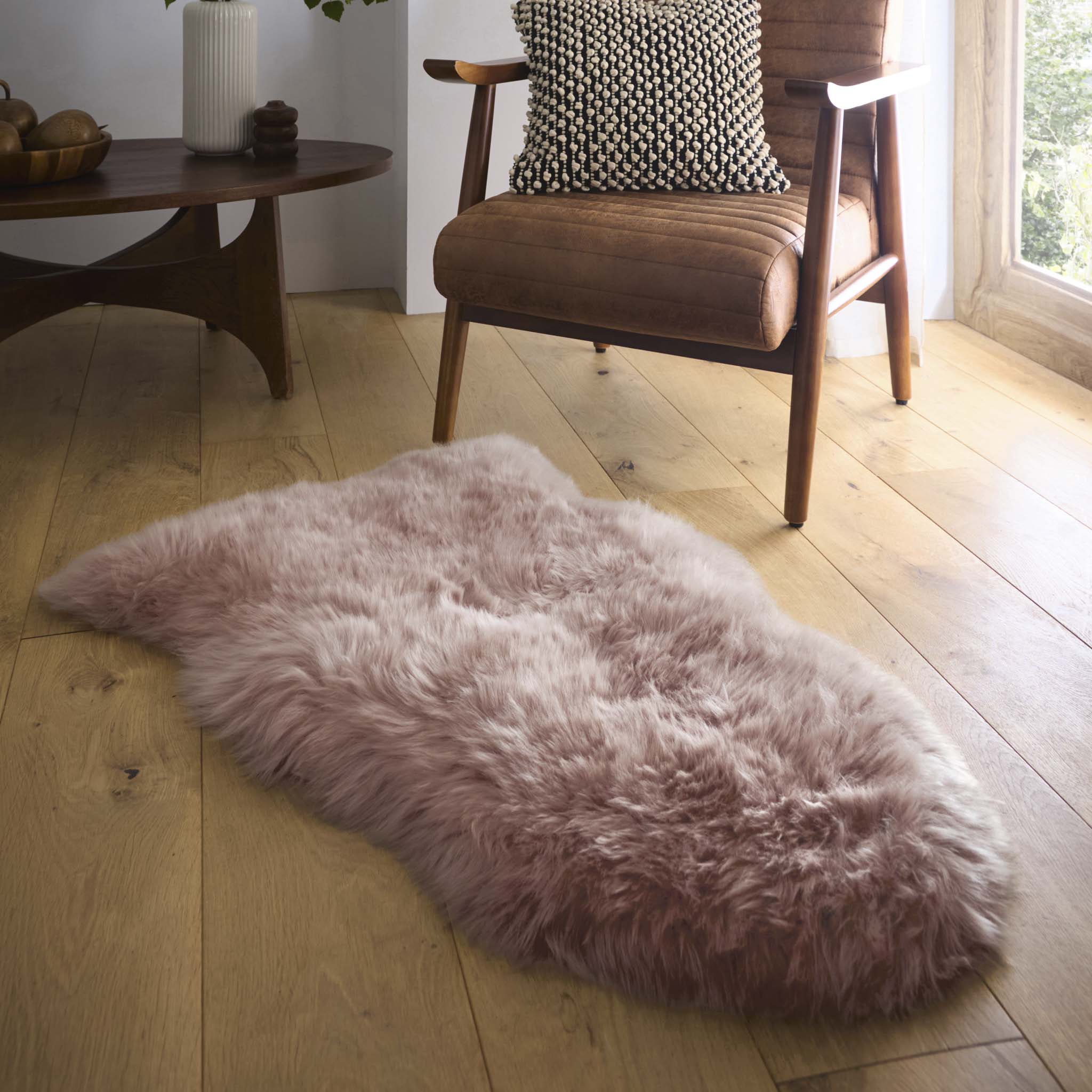 Single Sheepskin Rose Pink Rug made from long-haired wool, styled on wooden flooring.