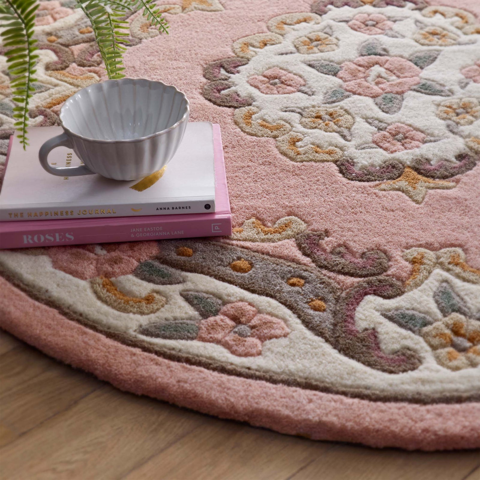 Shensi Pink Wool Rug with a traditional floral pattern, styled on wooden flooring.