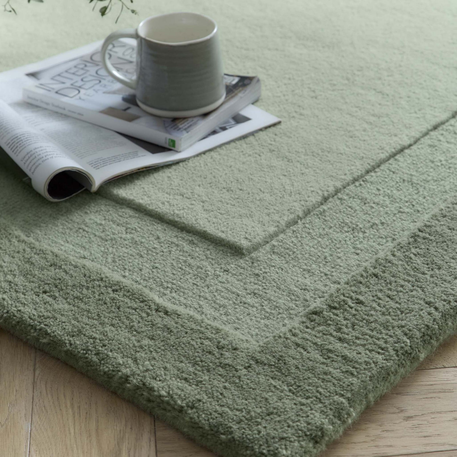 Stacked Borders Soft Green Rug. Made from 100% wool featuring a border design.
