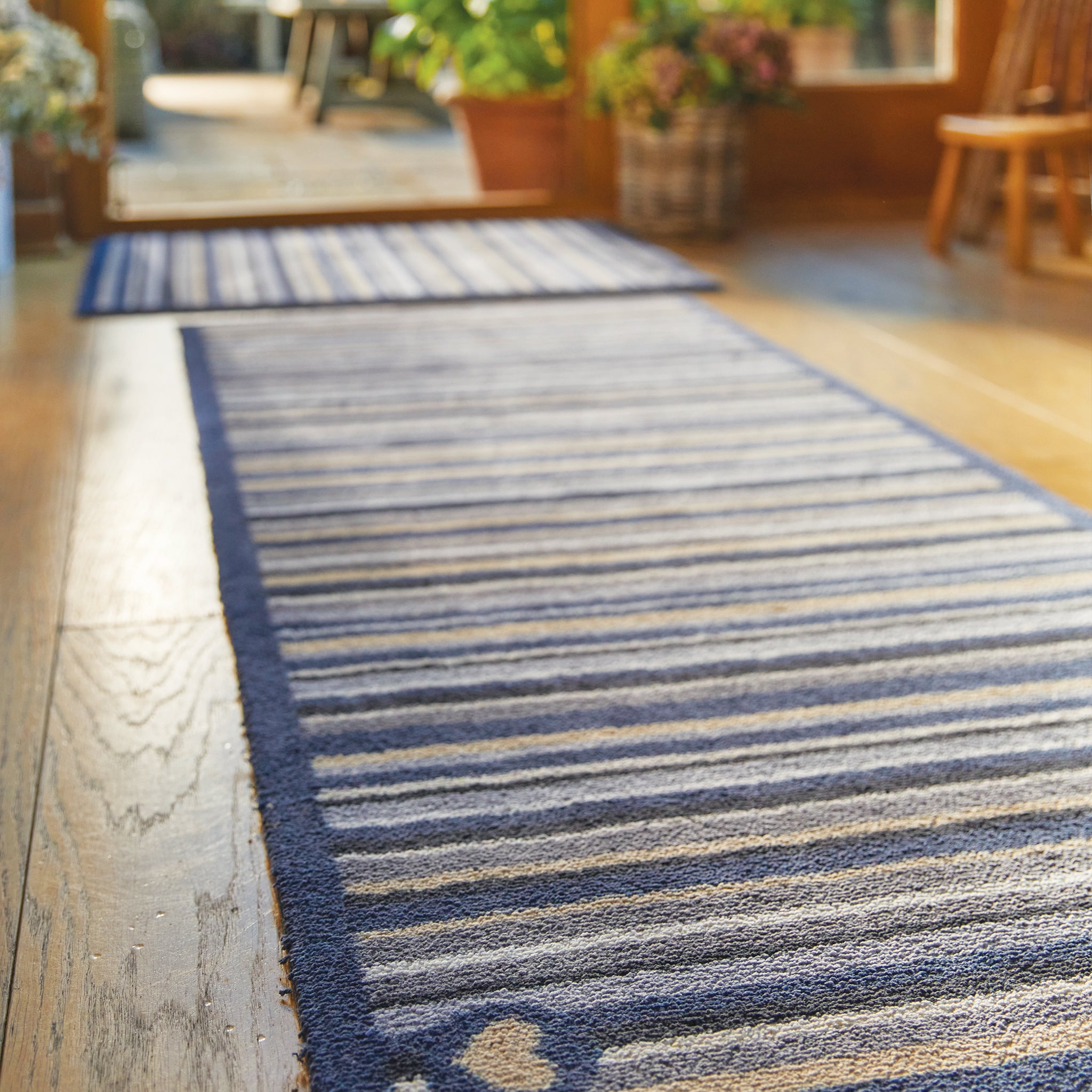 Stripe 88 Washable Runner- a 100% recycled cotton runner featuring an array of stripes in different shades of blue, grey, and beige. 