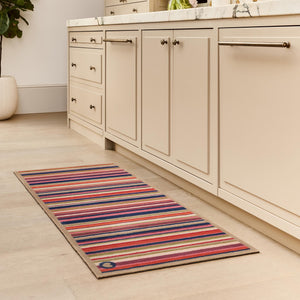 Sunset Stripe Washable Doormat- a wool washable runner featuring a cheerful mix of stripes in pink, green, white , orange ,blue and purple. 