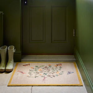 Thyme Walk Lichen & Gooseberry Washable Doormat with a yellow floral nature pattern , styled on stone floooring.