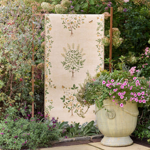 Thyme Walk Lichen & Gooseberry Eco-Washable Rug with a nature inspired pattern, styled on a wooden stand. 