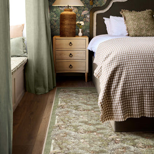 Treetop Troop Green Eco-Washable Rug with a forest and forest animal design, styled in a bedroom.