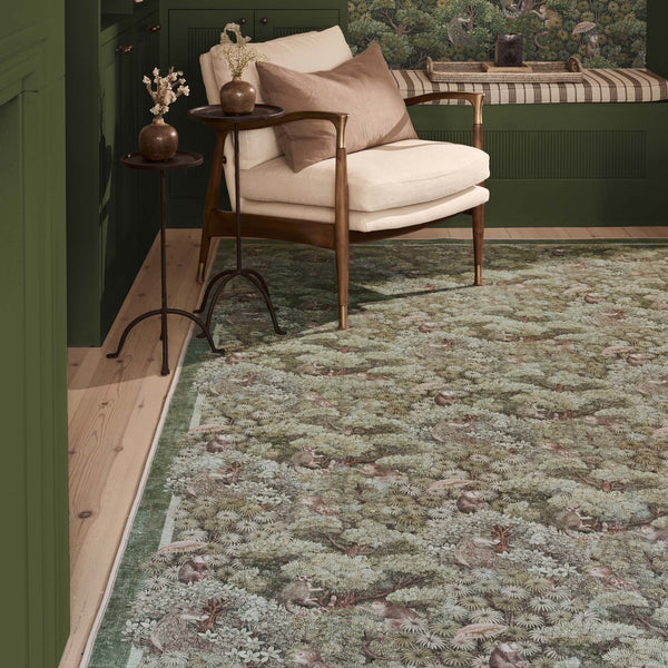 Treetop Troop Green Eco-Washable Rug with a forest and forest animal design, styled on wooden flooring.