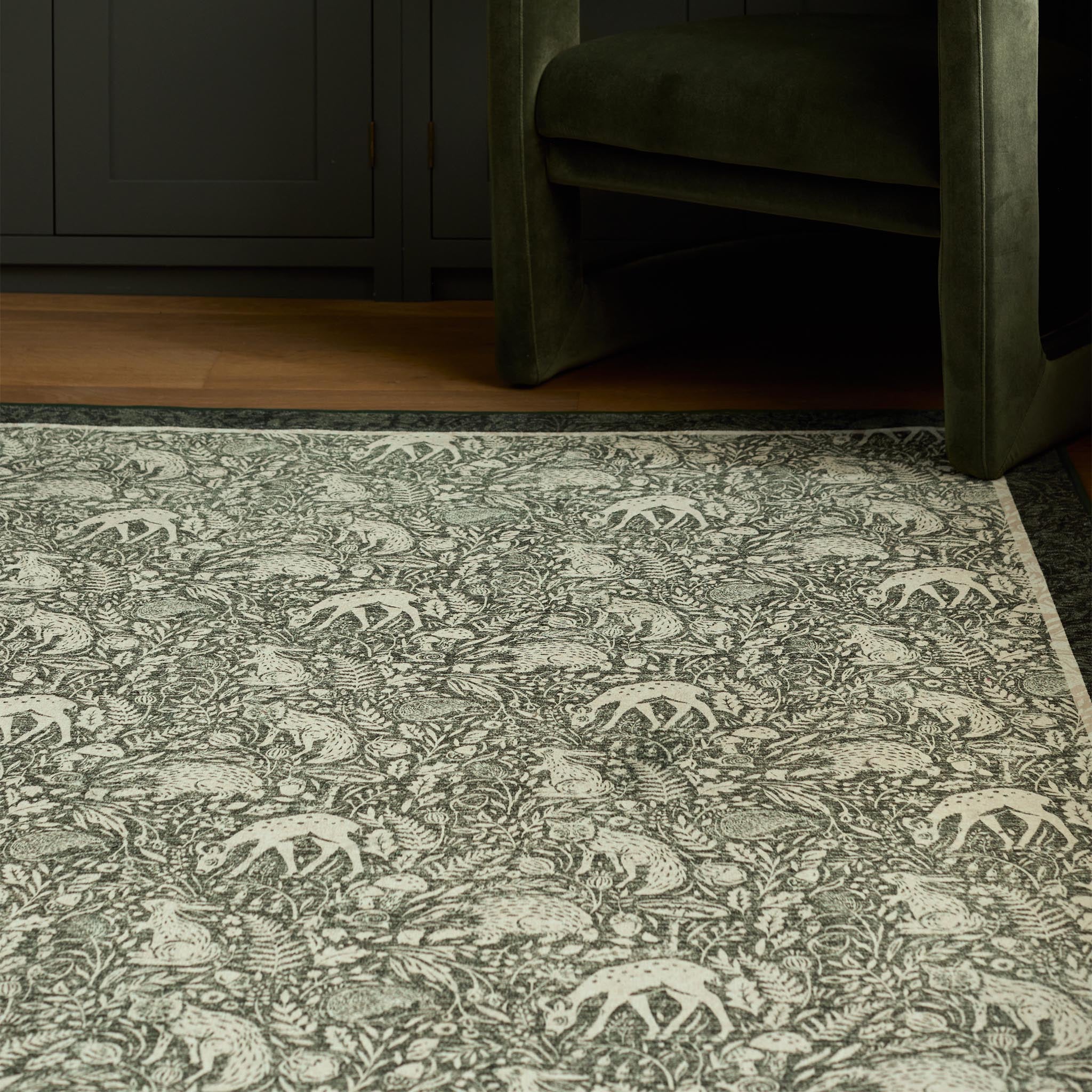 Whimsical Woodland Eco-Washable Rug – a green eco-washable rug featuring white woodland animals and white florals.
