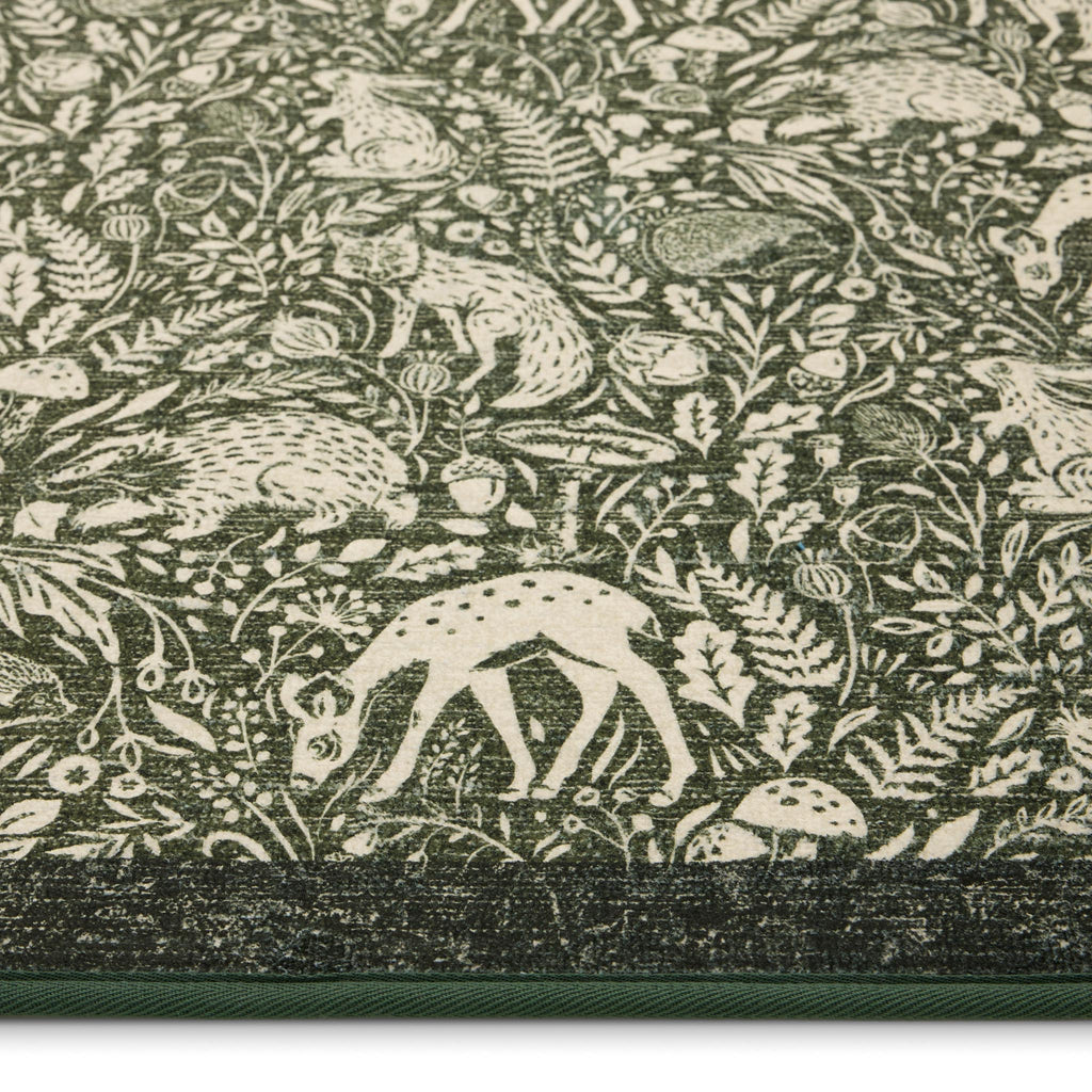 Whimsical Woodland Eco-Washable Rug – a green eco-washable rug featuring white woodland animals and white florals.