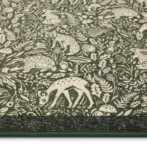 Whimsical Woodland Eco-Washable Rug – a green eco-washable rug featuring white woodland animals and white florals.