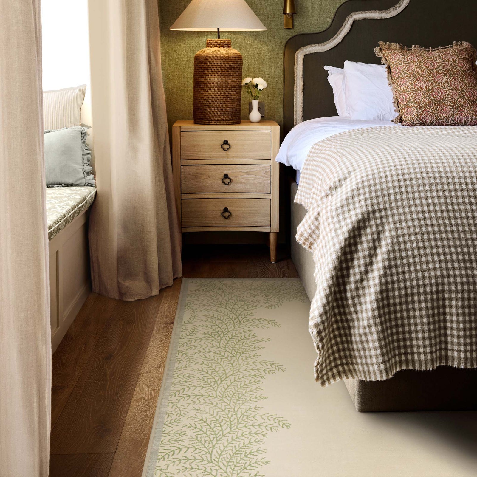 Whispering Fern Parchment Eco-Washable Rug with a fern leaf border design, styled under a bed. 
