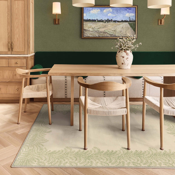 Whispering Fern Parchment Eco-Washable Rug with a fern leaf border design, styled under a kitchen table.