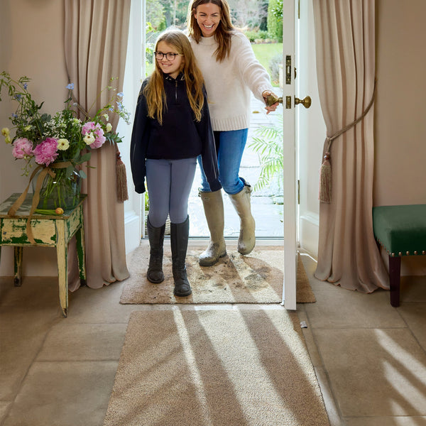 Hug Rug Cotton Washable Doormat with Muddy footprints in a doorway